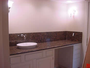 Private Residence, Chapel Hill. This Chapel Hill Master Bath vanity features a vessel sink that is partially recessed into the stone and a 12 inch high backsplash through which the plumbing fixtures are mounted.