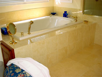 Private Residence, North Raleigh. This tub deck and skirt was created using 2cm Giallo Elan marble tile to match the marble slabs used on the vanities.