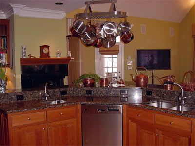 Private Residence, North Raleigh. This large, angled island has a raised bar, 2 undermount sinks and captured backsplash with holes for electrical outlets.