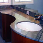 Private Residence, North Raleigh. Asymmetric curves characterize this vanity of Imperial Blue Opal Serene quartzite. A tubular steel substrate, designed and fabricated by Prescott Stone Fabricators supports the vanity from underneath.