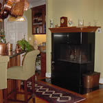 Private Residence, North Raleigh. This unusual corner fireplace surround is in the kitchen and is fabricated of Southern Black granite.  This granite is reminiscent of some of the marbles used on old soda fountains and has a soft, "old-timey" appearance.