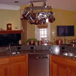 Private Residence, North Raleigh. This large, angled island has a raised bar, 2 undermount sinks and captured backsplash with holes for electrical outlets.