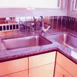 Private Residence, Hillsborough. Violetta granite, quarried in Saudi Arabia, was utilized for the counters in this kitchen. Due to the hardness and strength of this particular granite, we were able to cut two large holes, side by side, and configure two undermount sinks as preferred by t